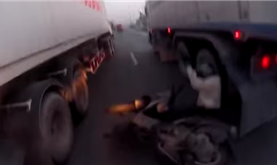 فيديو : دراج ينجو من بين عجلات شاحنتين على طريق سريع